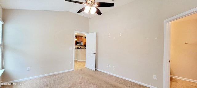 unfurnished bedroom with light carpet, baseboards, and vaulted ceiling