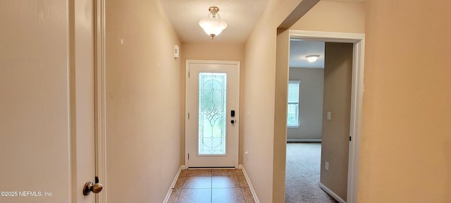 doorway to outside with carpet flooring and baseboards