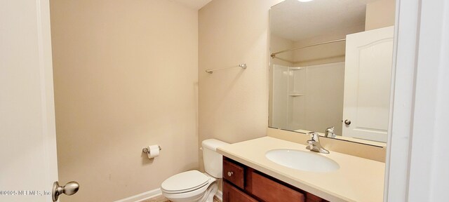 bathroom featuring baseboards, toilet, and vanity