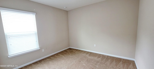 carpeted empty room with baseboards