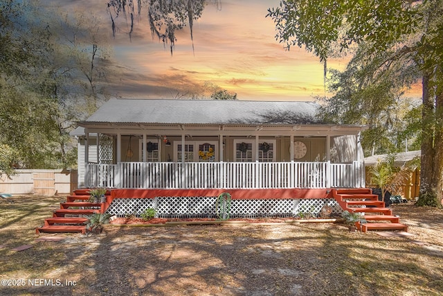 farmhouse featuring a porch and fence