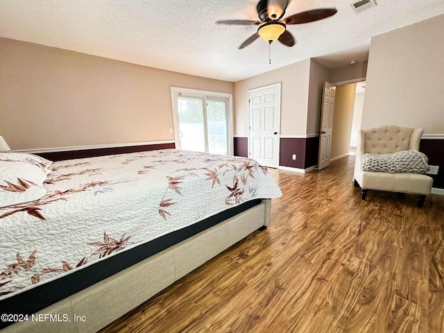 bedroom with hardwood / wood-style flooring, ceiling fan, access to outside, and a textured ceiling