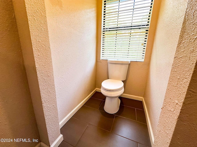 bathroom with toilet and tile patterned floors