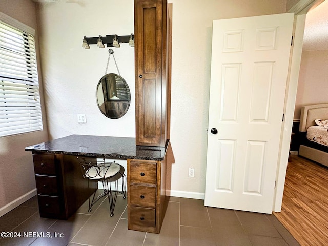 office with a wealth of natural light and dark tile patterned floors