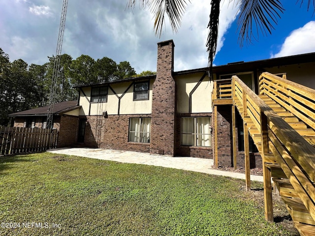 rear view of house with a patio and a lawn