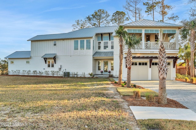 view of front of property featuring a front yard, a garage, and central air condition unit