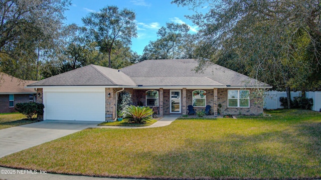 ranch-style home with a garage, a shingled roof, concrete driveway, and a front yard