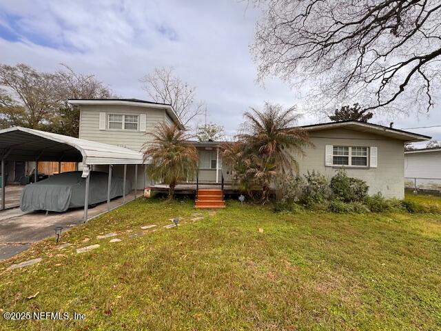 view of front of home with a front lawn and a carport