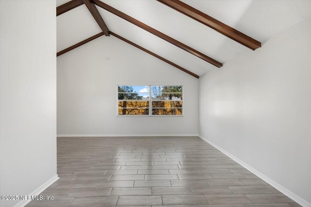 spare room with beam ceiling and high vaulted ceiling