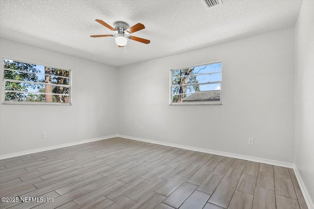 empty room with light hardwood / wood-style floors, ceiling fan, and a textured ceiling