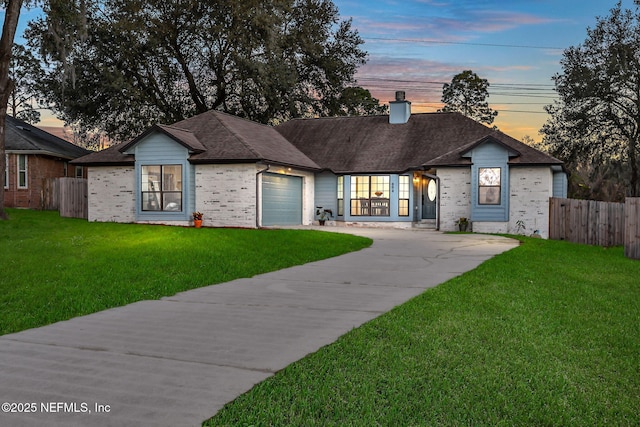 single story home featuring a garage, concrete driveway, a front lawn, and a chimney