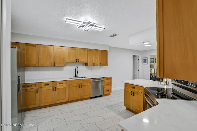 994 Lakeridge Dr, Orange Park, FL 32065 - kitchen featuring a sink, visible vents, light countertops, appliances with stainless steel finishes, and brown cabinetry