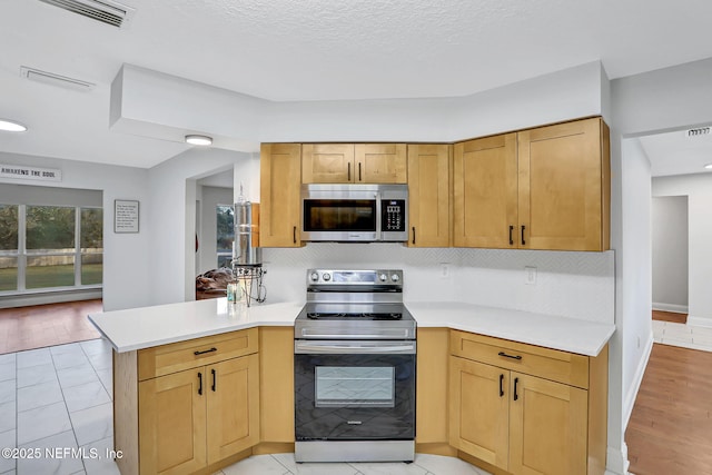 994 Lakeridge Dr, Orange Park, FL 32065 - kitchen with light countertops, appliances with stainless steel finishes, a peninsula, and backsplash