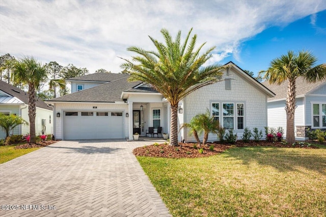 view of front of house featuring a garage, decorative driveway, and a front yard