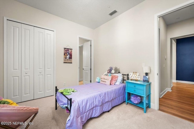 bedroom featuring carpet, a closet, visible vents, and baseboards