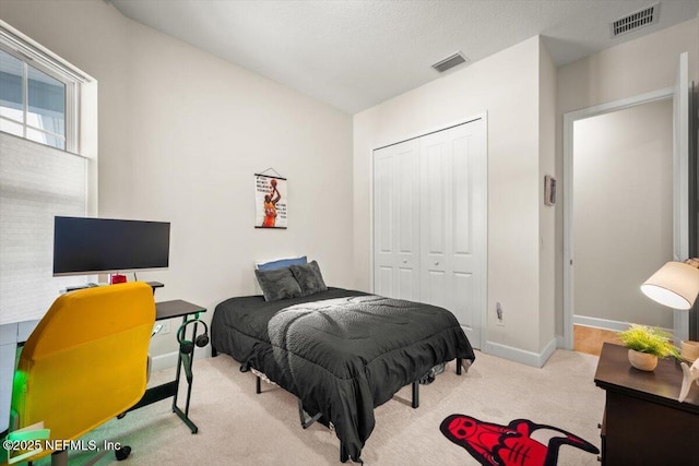 bedroom featuring carpet floors, baseboards, visible vents, and a closet