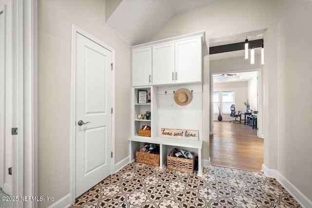 mudroom with lofted ceiling, baseboards, and tile patterned floors