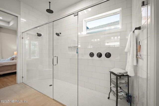 bathroom with a shower stall, ensuite bath, and tile patterned floors