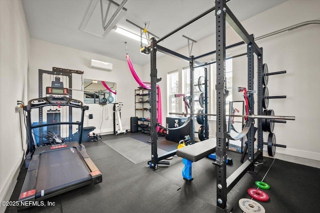 gym featuring baseboards and a wall mounted AC