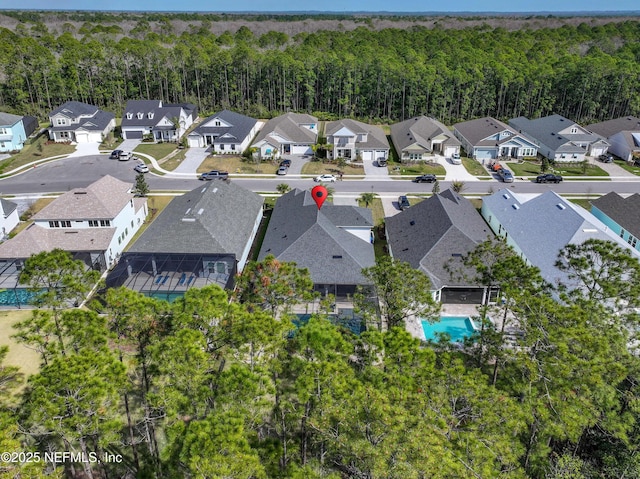 drone / aerial view with a residential view and a view of trees