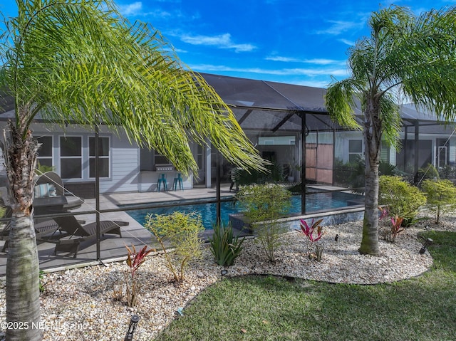 pool featuring glass enclosure and a patio area