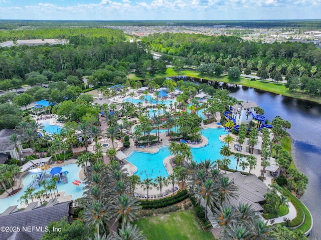 birds eye view of property featuring a water view and a wooded view