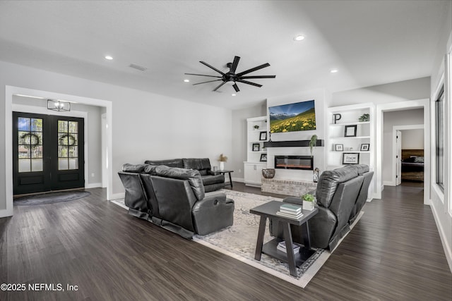 living area with a fireplace, visible vents, dark wood-type flooring, and recessed lighting