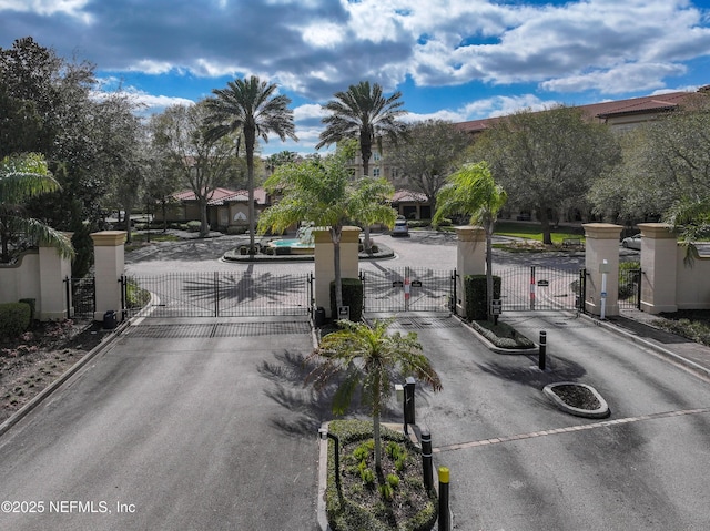 view of street featuring curbs, a gated entry, and a gate