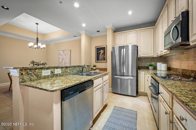 kitchen with cream cabinetry, decorative light fixtures, decorative backsplash, appliances with stainless steel finishes, and a sink