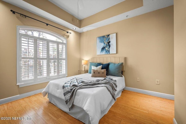 bedroom with wood finished floors and baseboards