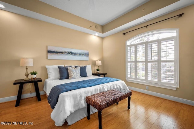 bedroom with baseboards and wood finished floors