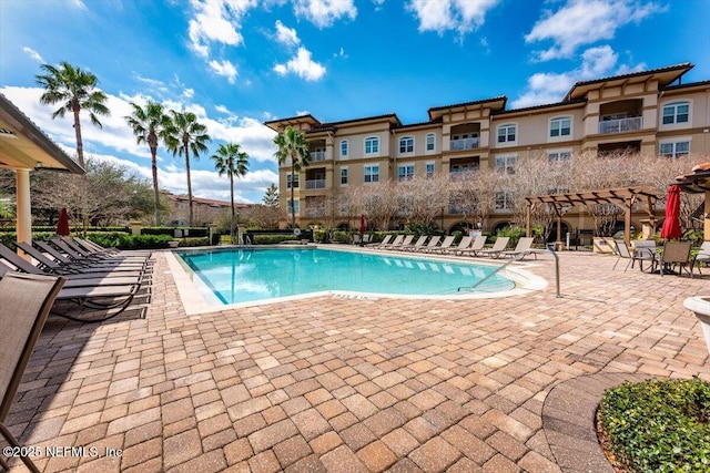 community pool with a patio area and a pergola