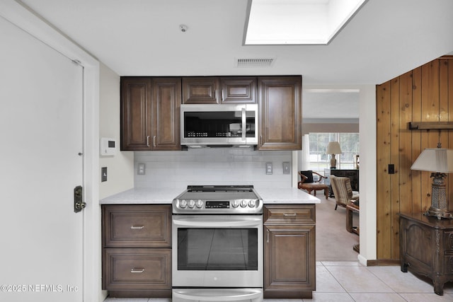 kitchen with dark brown cabinetry, visible vents, appliances with stainless steel finishes, and backsplash