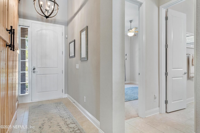 95384 Bermuda Dr, Fernandina Beach, FL 32034 - foyer entrance featuring ceiling fan with notable chandelier, baseboards, and light tile patterned floors