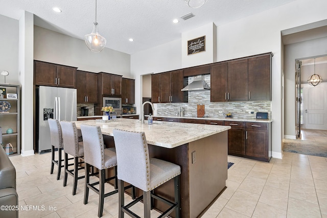 95384 Bermuda Dr, Fernandina Beach, FL 32034 - kitchen featuring a breakfast bar, tasteful backsplash, wall chimney exhaust hood, and appliances with stainless steel finishes