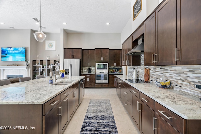95384 Bermuda Dr, Fernandina Beach, FL 32034 - kitchen with tasteful backsplash, a sink, dark brown cabinetry, stainless steel appliances, and wall chimney exhaust hood