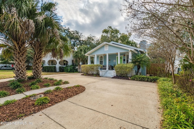 view of front of home with covered porch, driveway, and a chimney