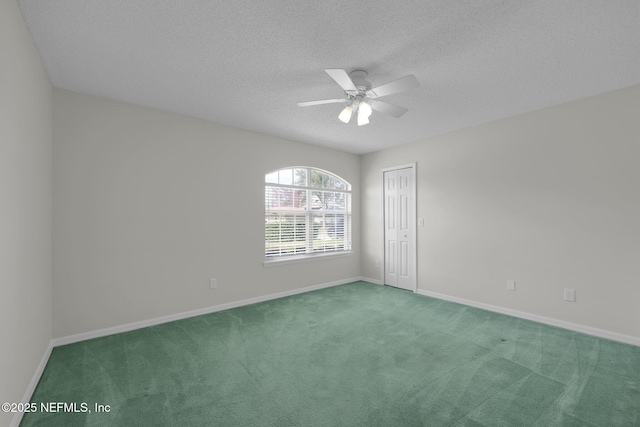 empty room with a textured ceiling, carpet floors, a ceiling fan, and baseboards