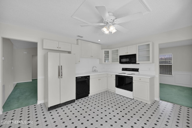 kitchen featuring white cabinets, black appliances, glass insert cabinets, and light countertops