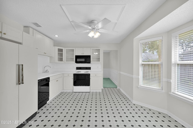 kitchen featuring black appliances, light countertops, glass insert cabinets, and white cabinetry