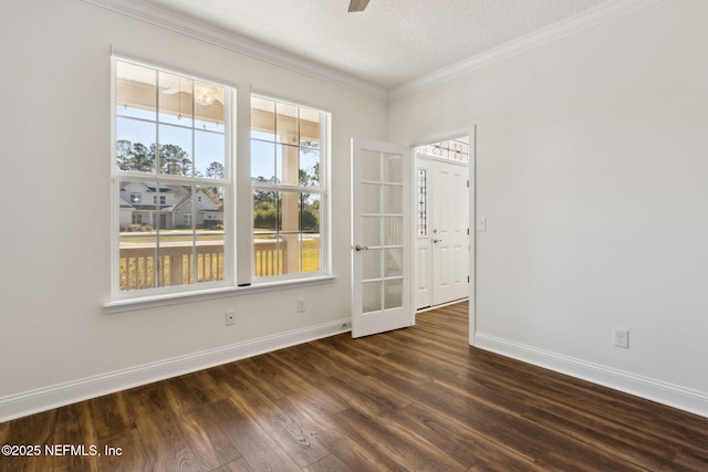 empty room with ceiling fan, a textured ceiling, dark wood-type flooring, baseboards, and ornamental molding