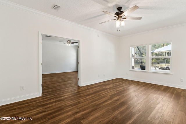 empty room with dark wood-type flooring, visible vents, ornamental molding, and baseboards