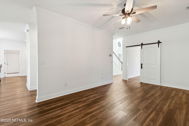 unfurnished room featuring a barn door, visible vents, dark wood-style floors, ceiling fan, and ornamental molding