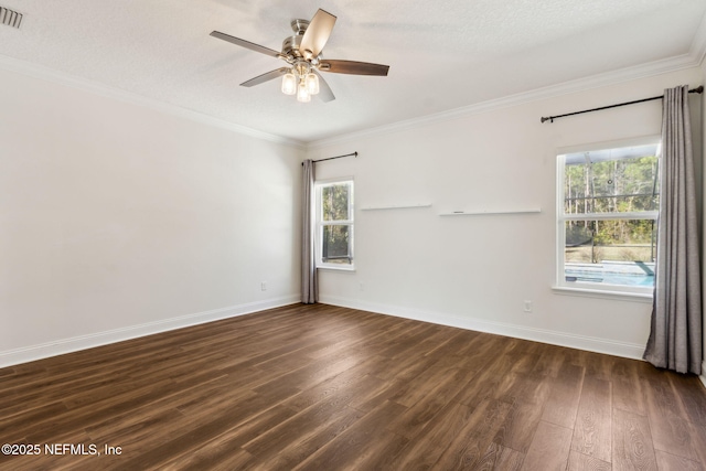 unfurnished room with dark wood-type flooring, a wealth of natural light, crown molding, and baseboards