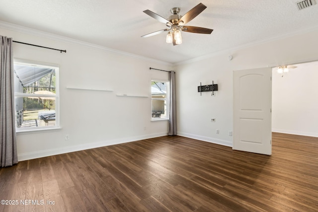 spare room featuring dark wood-style floors, visible vents, and a healthy amount of sunlight