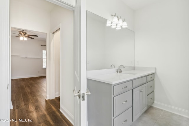 bathroom featuring a ceiling fan, vanity, baseboards, and wood finished floors