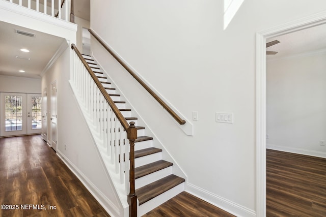 staircase with ornamental molding, baseboards, and wood finished floors