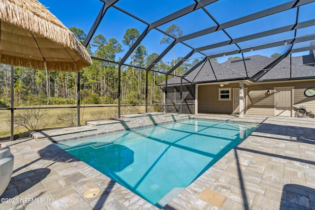 outdoor pool with glass enclosure and a patio area