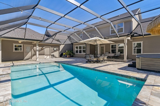 outdoor pool with a lanai, a patio area, and a hot tub