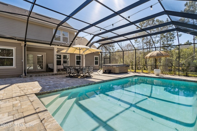 outdoor pool featuring glass enclosure, french doors, a patio area, and a hot tub